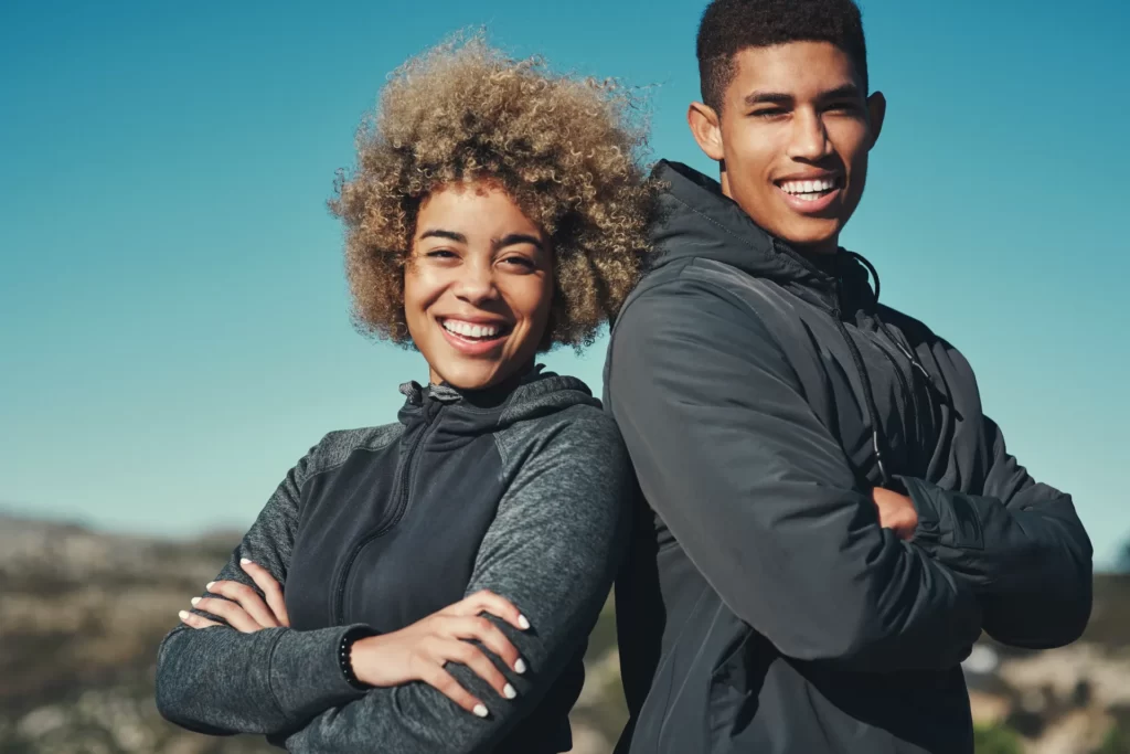 smiling young adults back to back outdoors utc